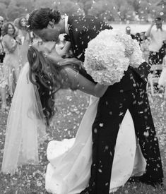 a bride and groom kiss as they are surrounded by confetti