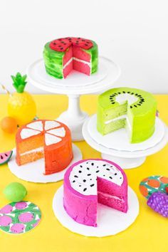 there are many different cakes on the table with pineapples and watermelon slices