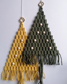 two crocheted christmas trees hanging from strings