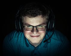 a young man wearing headphones and smiling at the camera with his eyes wide open