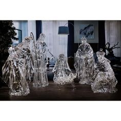 three clear glass figurines sitting on top of a table next to a christmas tree