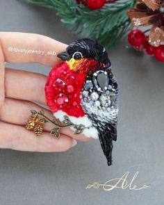 a small bird sitting on top of a person's hand next to christmas decorations