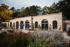 an old brick building surrounded by trees and plants