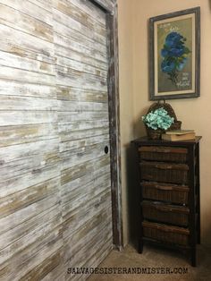 a room with a dresser and a painting on the wall next to an open door