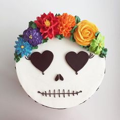 a cake decorated to look like a skull with flowers on it