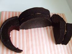 a chocolate cake is cut into pieces on a pink and white striped paper