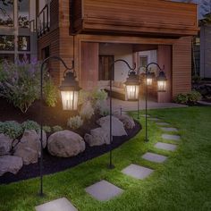 a house with stone steps leading up to the front door and side yard at night