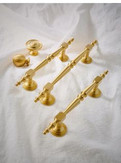 four brass door handles and knobs on a white sheet