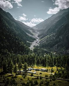 the valley is surrounded by mountains and trees