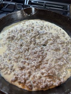 an uncooked pizza in a cast iron skillet on top of the stove