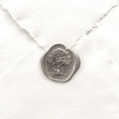 an old coin is sitting on top of a piece of white paper that has been torn off