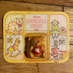 a brown teddy bear sitting inside of a yellow box on top of a wooden floor