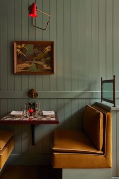 a small table with two chairs and a painting on the wall