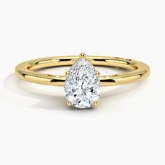 a yellow gold engagement ring with a pear shaped diamond on the top and side view