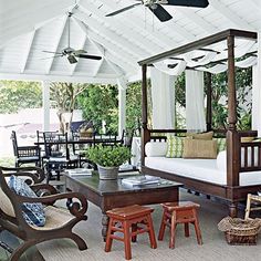 an outdoor living area with furniture and ceiling fans