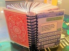 an open book sitting on top of a table next to a cell phone and keyboard