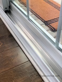 an open window on the side of a building with wood flooring and glass doors