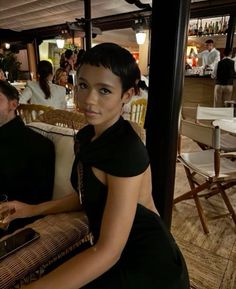 a woman in a black dress sitting at a table