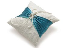 a white and blue pillow with a bow on it