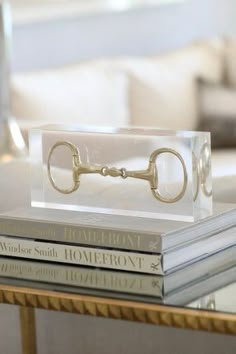 a glass table topped with books and a golden key on top of each bookcase