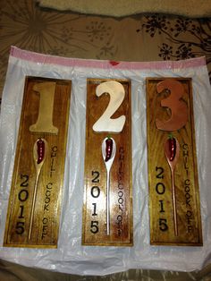 three wooden spoons with numbers and peppers on them