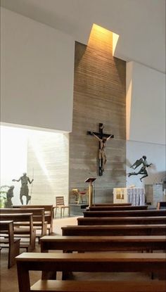 the inside of a church with pews and crucifix on the wall