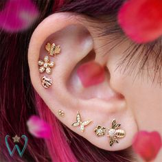 an ear with five different stars and moon designs on the inside of it, as well as two piercings