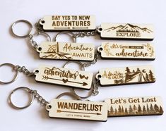 six wooden keychains with the words wanderlust printed on them, all in different shapes and sizes