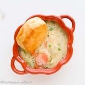 a red bowl filled with food on top of a white table