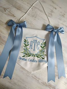 an embroidered banner hanging on the wall with blue ribbon and bow around it that says epic made cotton millery