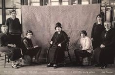 an old black and white photo of people in front of a quilted wall hanging