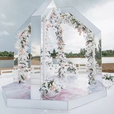 a large mirror sitting on top of a white table covered in flowers and greenery