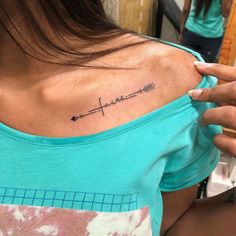 a woman with a cross tattoo on her upper arm and the word faith written in cursive writing