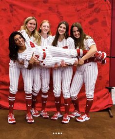 a group of women in baseball uniforms posing for a photo