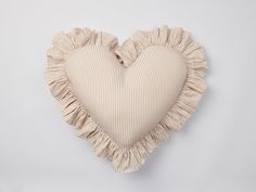 a heart shaped pillow with ruffled edges on a white background in the shape of a heart