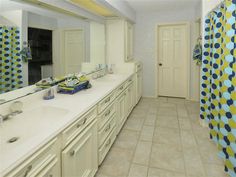 a large bathroom with two sinks and a shower curtain in the middle of the room