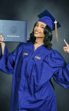 a woman in blue graduation gown holding up her diploma