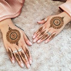 two hands with henna designs on them