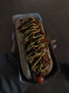 a hot dog with mustard and ketchup on it's side in a box