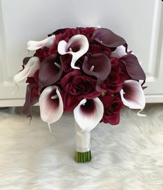 a bridal bouquet with red and white calla lilies on a furnishing