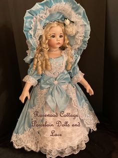 the doll is wearing a blue dress and bonnet