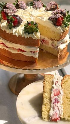 a cake with strawberries on top and two slices cut from the cake are sitting next to each other