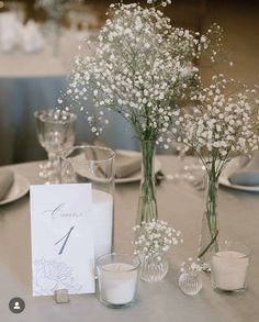 the table is set with flowers and place cards for guests to sign their names on