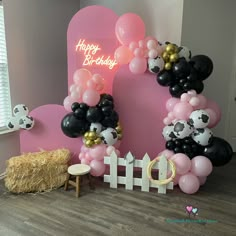 the balloon arch is decorated with black, white and pink balloons