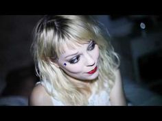 a woman with long blonde hair and makeup looks at the camera while wearing red lipstick