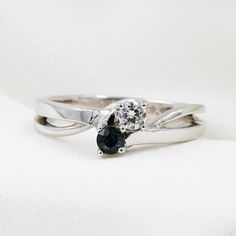 a couple of rings that are sitting on top of each other's fingers and one has a black diamond in the middle