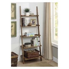 a wooden ladder shelf with books on it in a living room next to a window