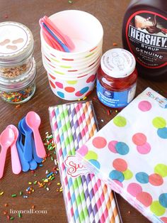 party supplies and confetti are laid out on a wooden table with paper napkins