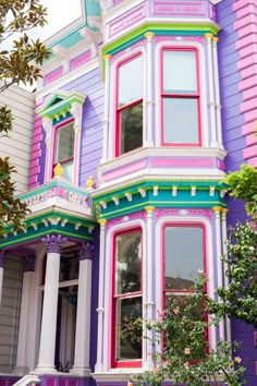 a multi - colored house with many windows and balconies in the front yard