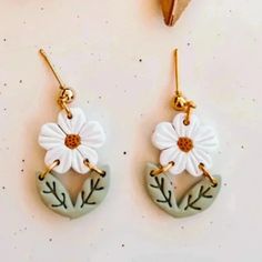 two pairs of earrings with flowers on them